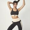 Top deportivo en negro con contrastes blanco . Apertura mediante cremallera delantera y espalda cruzada .Copas acolchadas sin aros y con foam extraíbles.