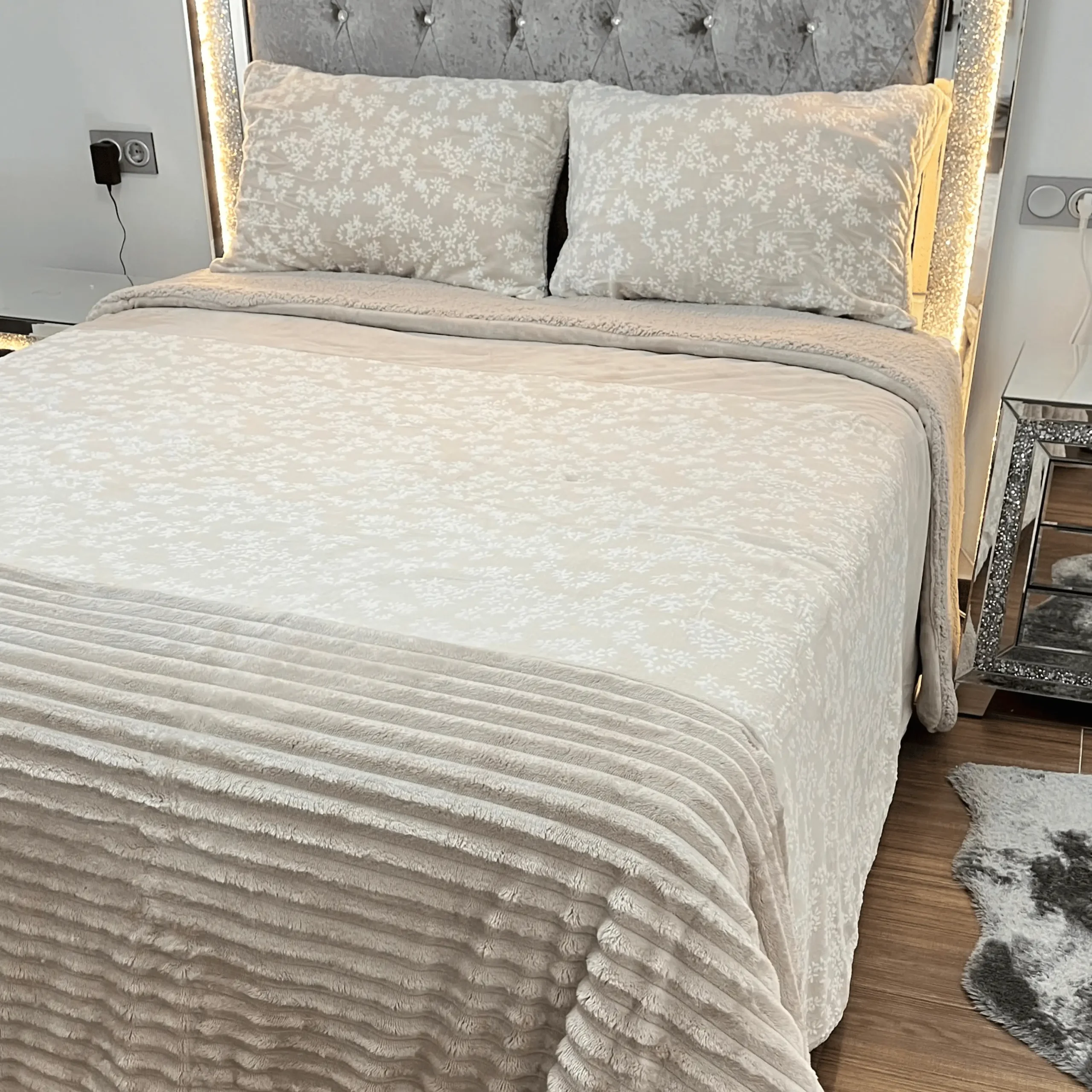Dormitorio elegante con cama vestida con el edredón Sherpa Anabella de Dolz, que combina una textura aterciopelada con diseño floral en la parte superior y tejido tipo borreguito en la inferio